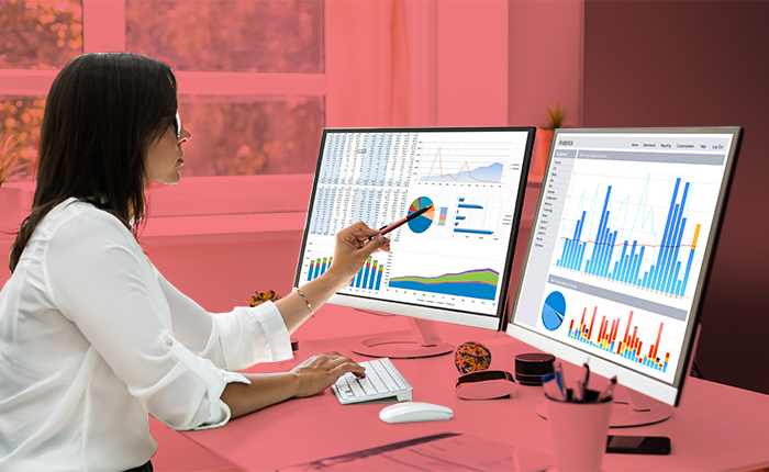 indicadores de marketing - mulher olhando dois monitores com dados